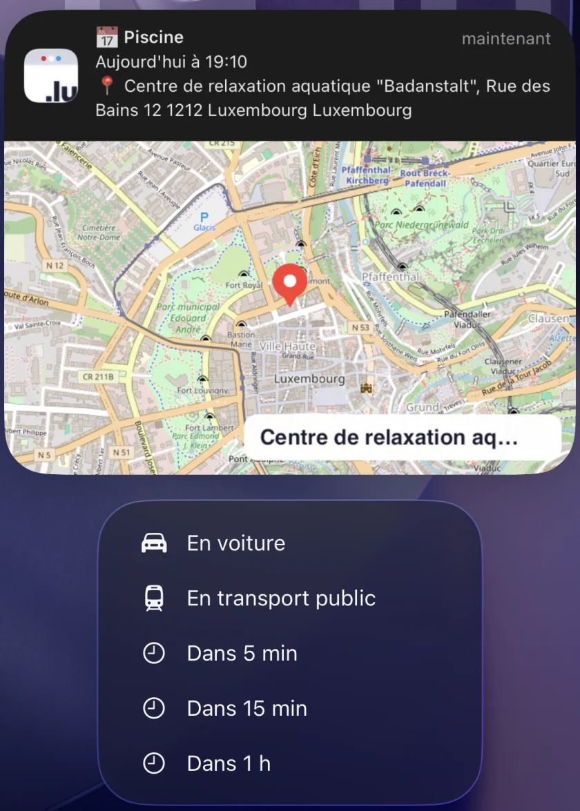 Notification d'événement affichant le lieu sur une carte avec vignette de la rue, et les actions En voiture et En transport public